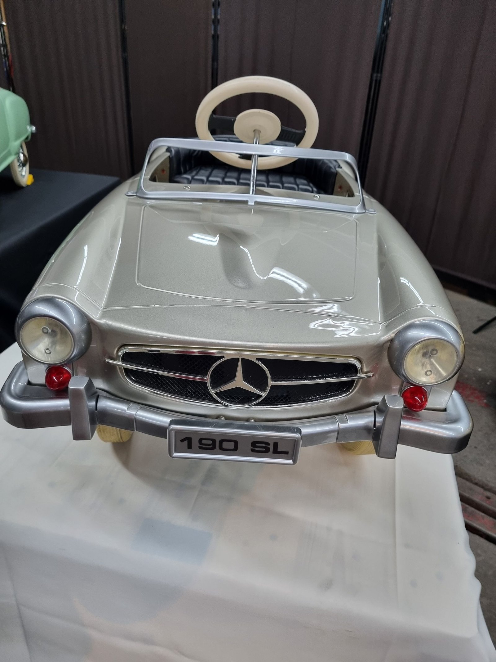 Auf einem Tisch steht ein Mercedes-Benz 190 SL-Tretauto.